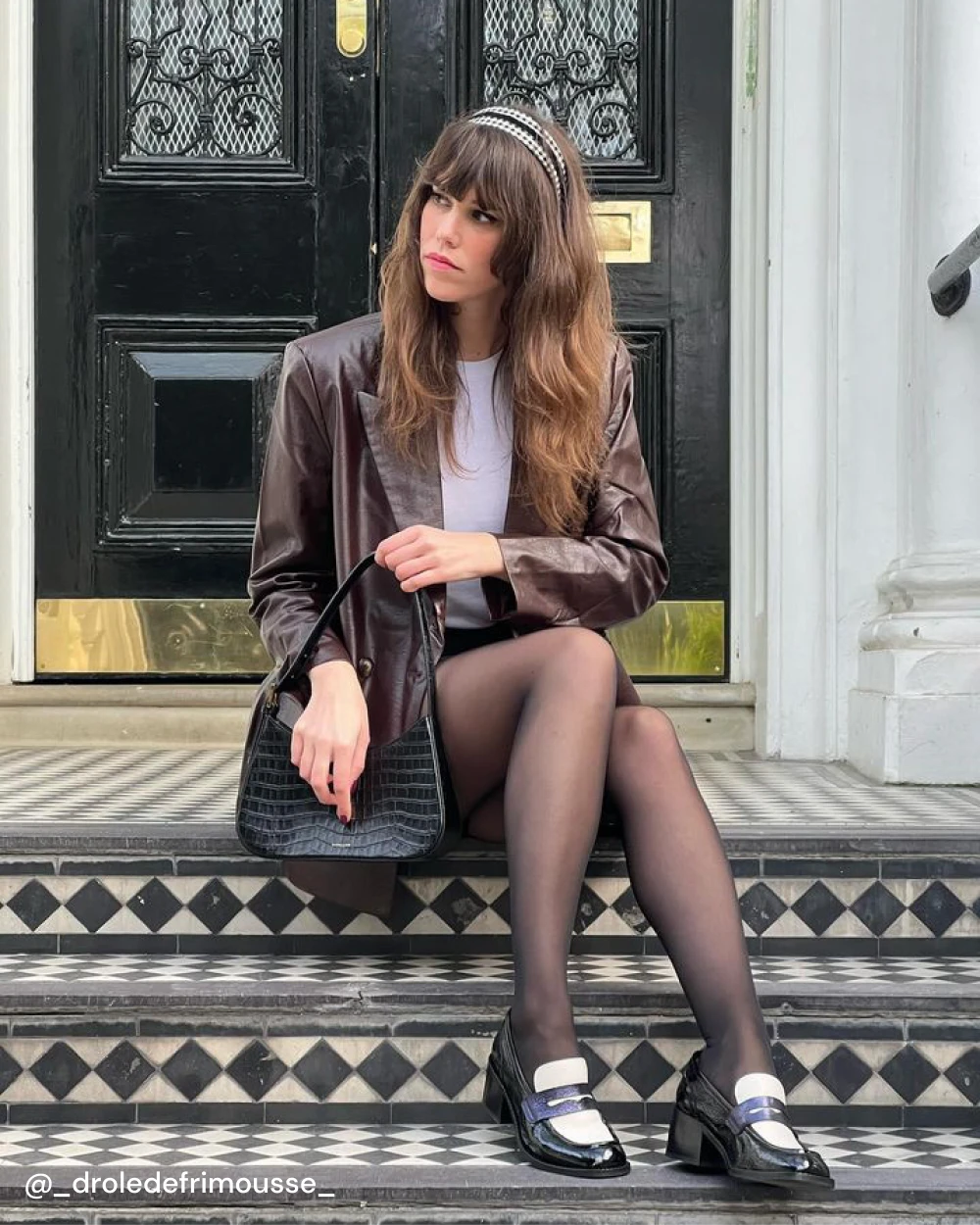 Ambre porte les mocassins à talons PABLO avec une jupe et un blazer en cuir marron