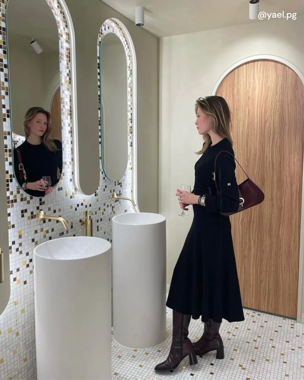 Yael porte les bottes CRISTOBAL à talon en cuir bordeaux embossé crocro